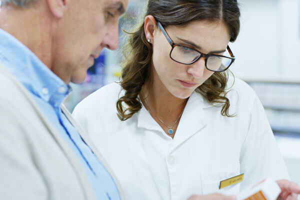 pharmacist assisting patient with repeat prescription at townsend pharmacy