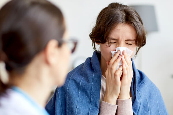 Woman with flu symptoms talking to a healthcare professional