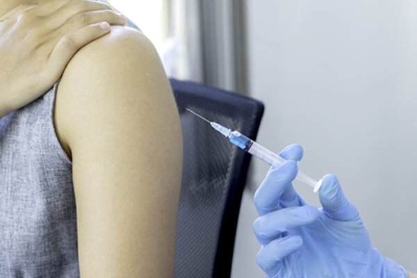 person receiving a flu vaccination in the upper arm